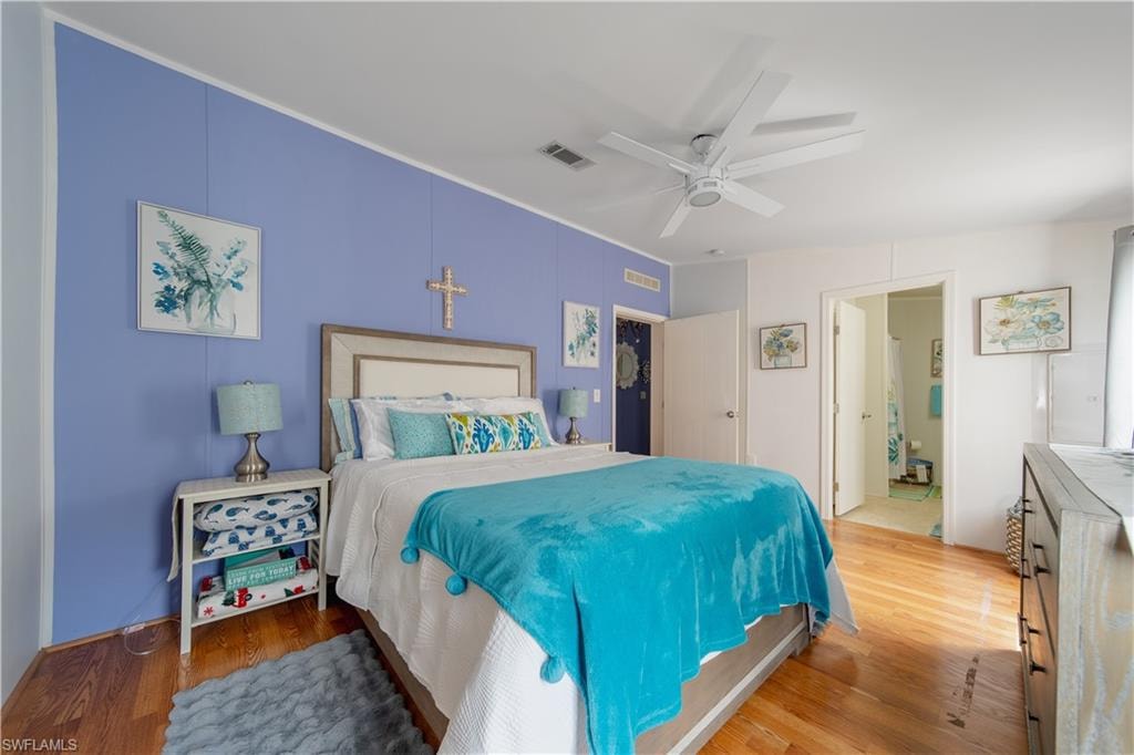 Bedroom with wood finished floors, a ceiling fan, and ornamental molding