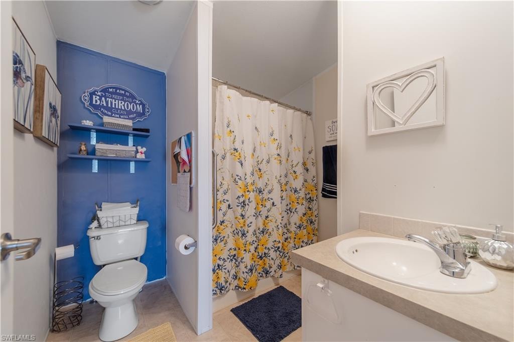 Bathroom featuring vanity, a shower with shower curtain, and tile patterned flooring