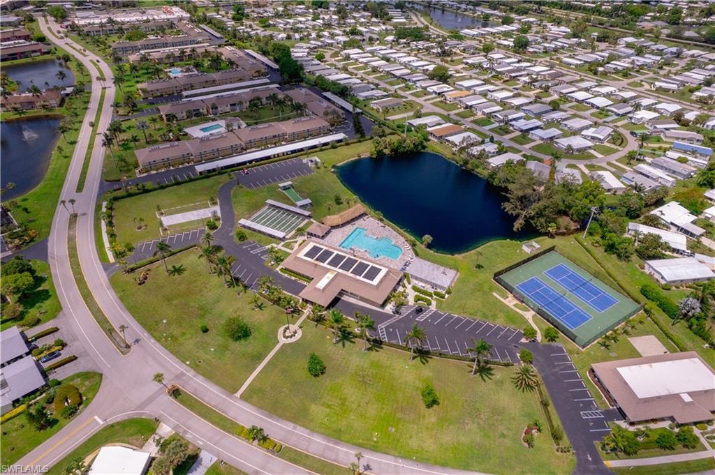 Aerial view of property and surrounding area with a nearby body of water and a pool area