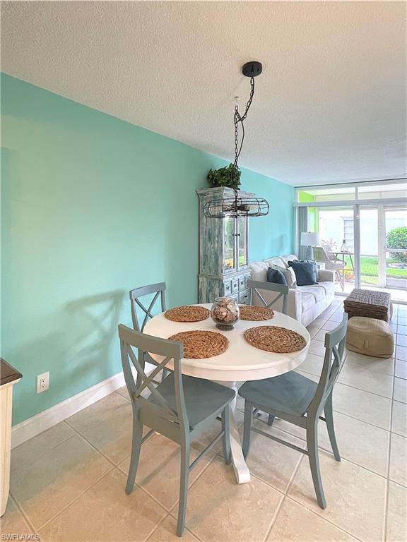 Dining area featuring a textured ceiling and light tile patterned floors