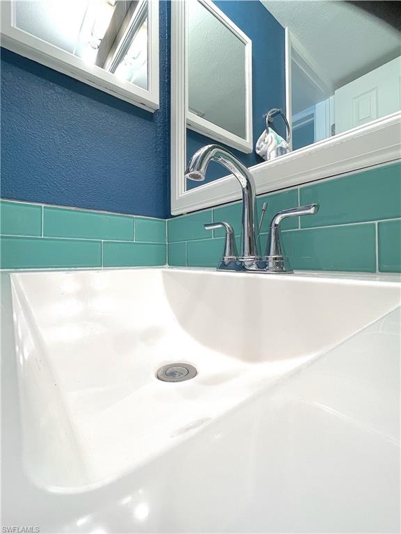 Bathroom view of a sink and a textured wall