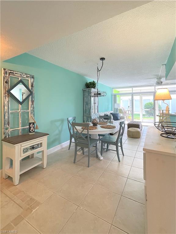 Dining room with a textured ceiling and light tile patterned floors
