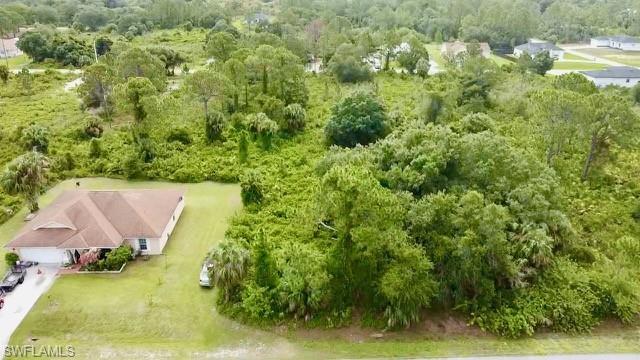 Aerial view of property and surrounding area featuring a forest