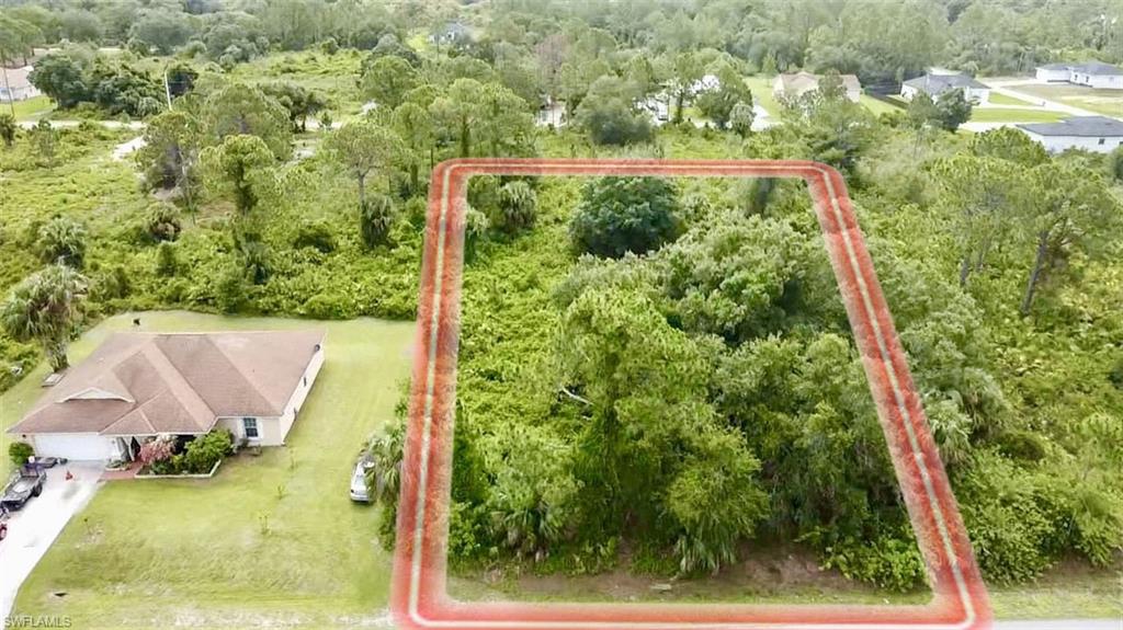 Aerial view of property and surrounding area featuring a heavily wooded area and property boundaries highlighted