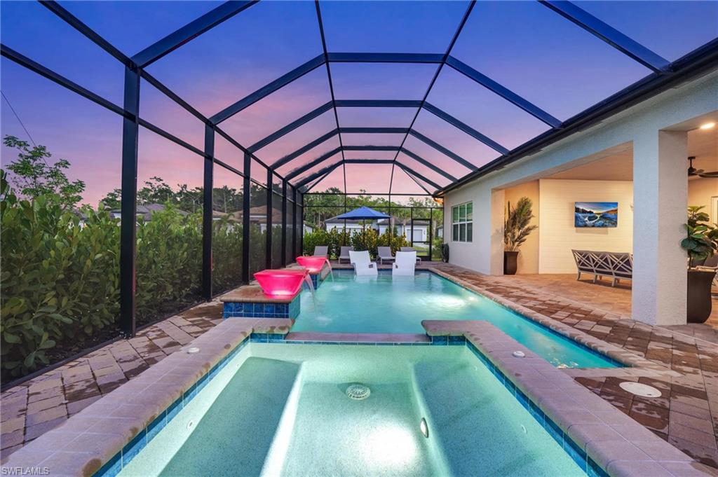 View of pool with a patio and a pool with connected hot tub
