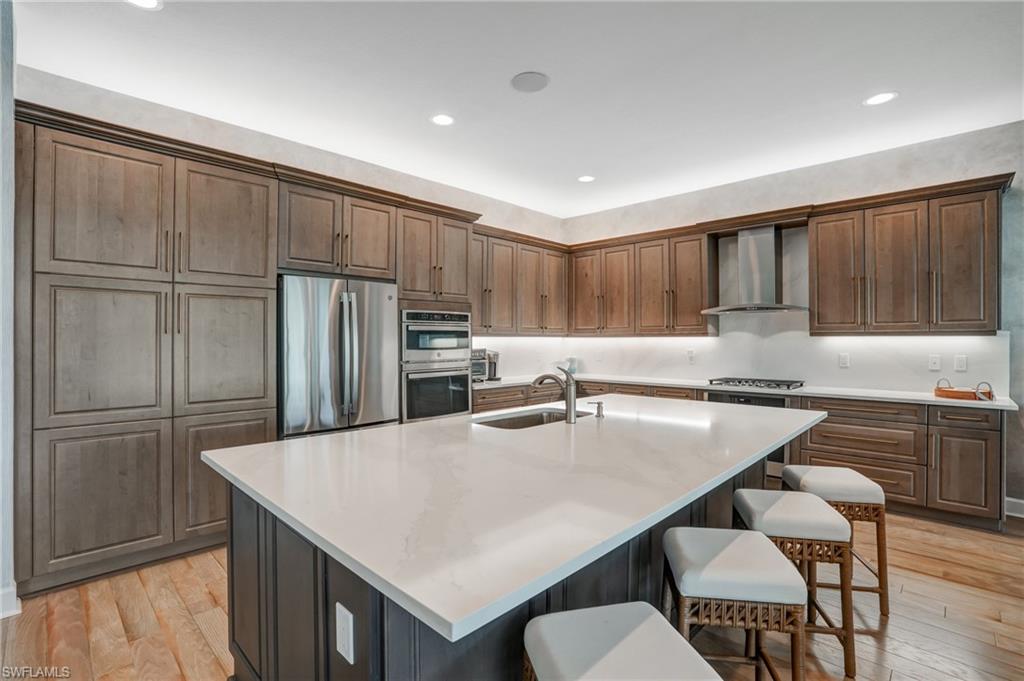 Large kitchen with Quartz countertops and full backsplash,  GE Profile French door refridgerator, double convection ovens, built in microwave, vent hood, wine cooler