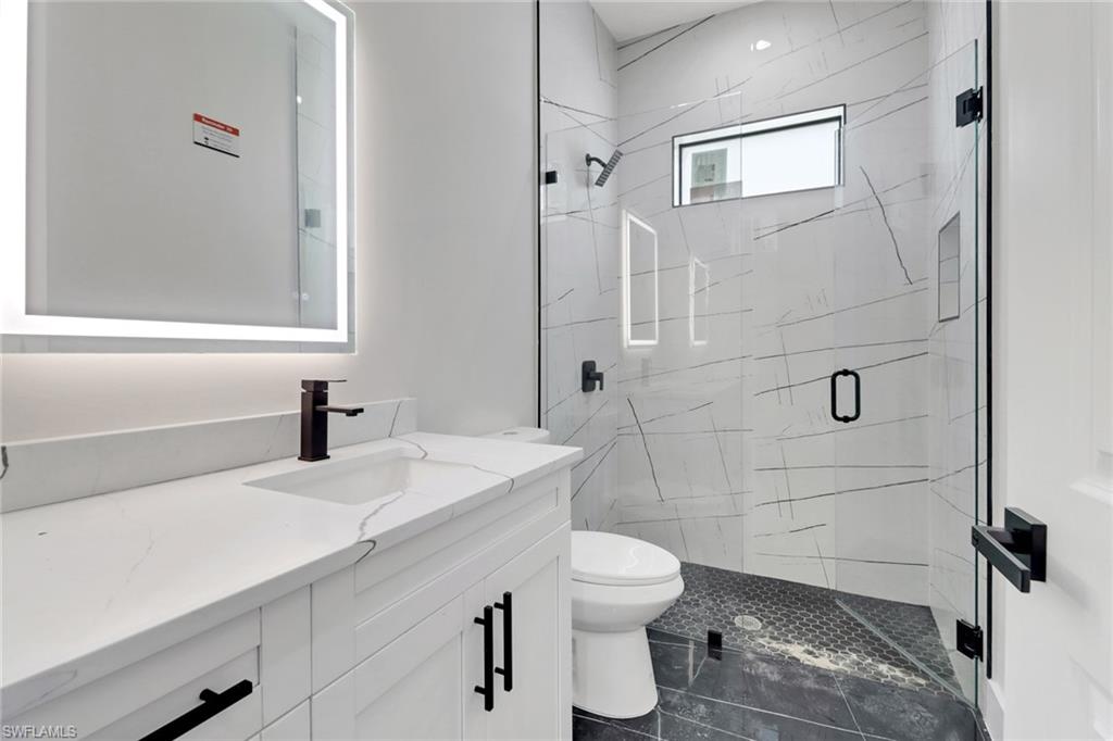 Guest bathroom featuring upgraded vanity and shower with frameless glass enclosed shower