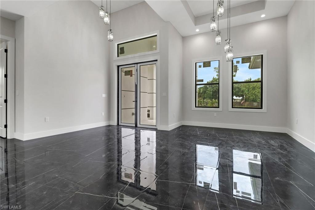 Entry featuring a high ceiling, tile flooring, and modern lighting