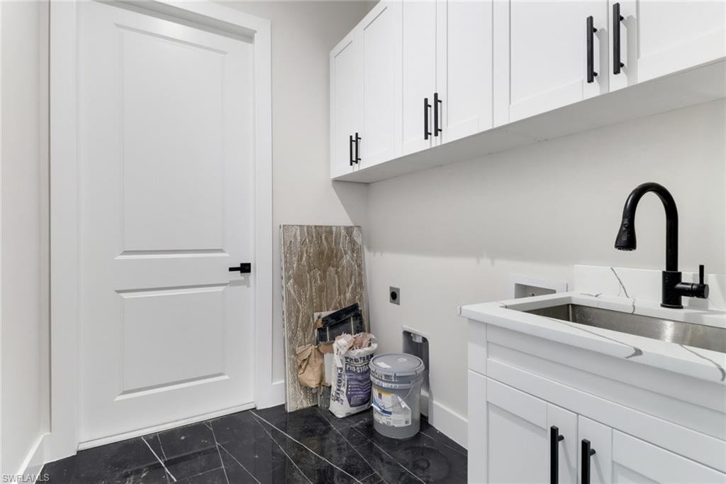 Laundry room with washer / dryer hookup, abundant cabinet space, laundry sink and tile floors