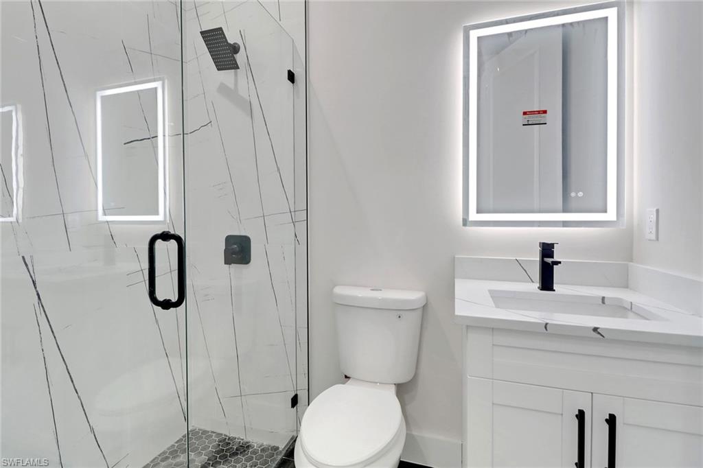 Full bathroom featuring vanity and a upgraded shower with glass door