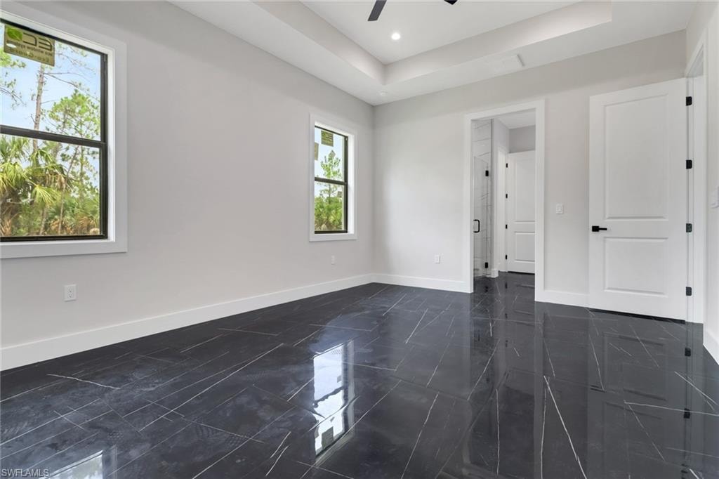 Light and bright primary bedroom with tile flooring and en suite bathroom