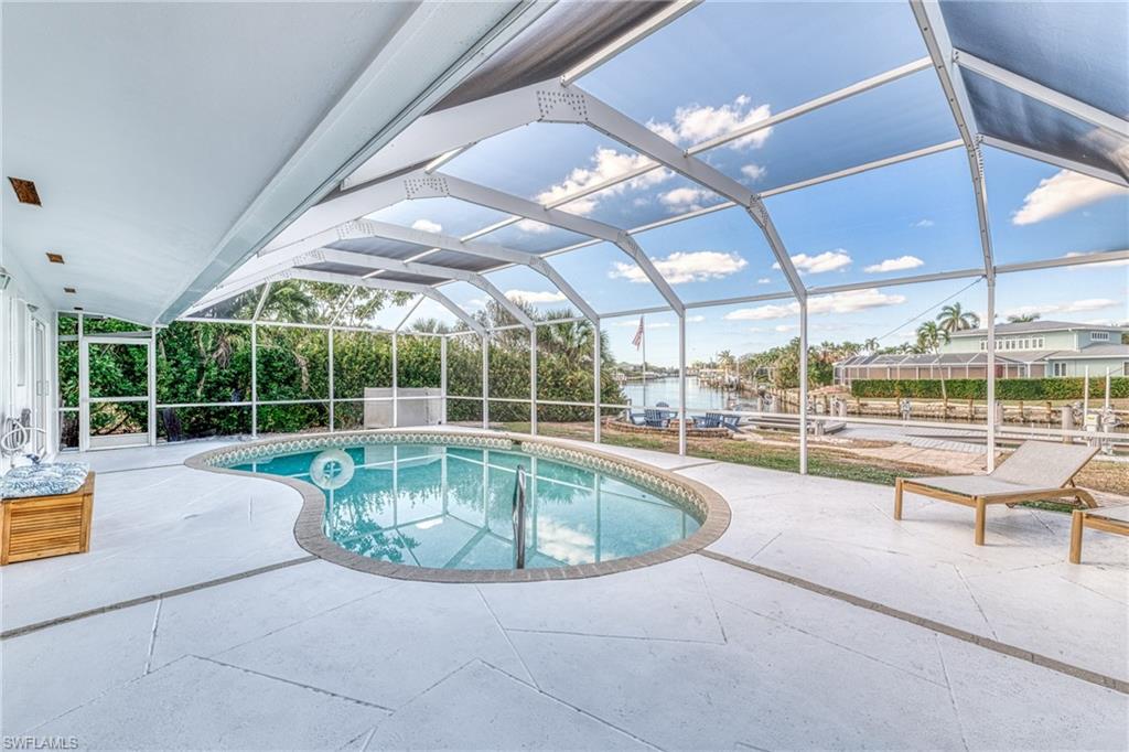 Swimming pool featuring a patio area and glass enclosure