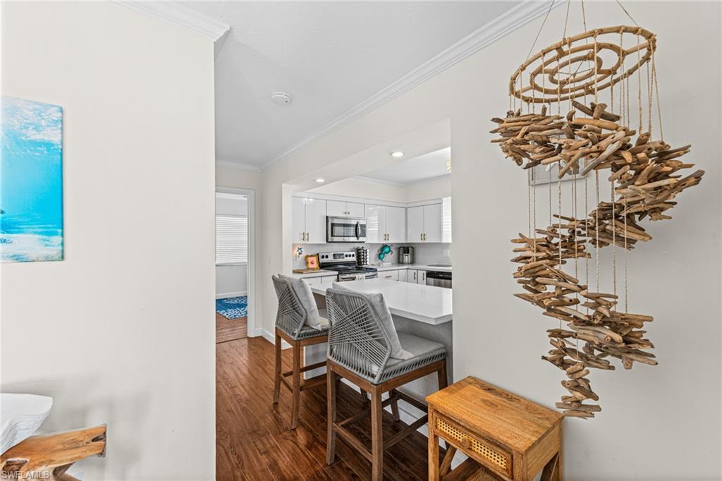 Dining space featuring crown molding, wood finished floors, and recessed lighting