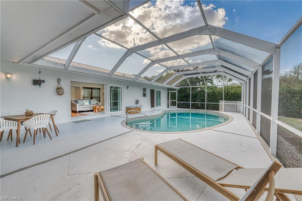 Outdoor pool with a patio area and glass enclosure