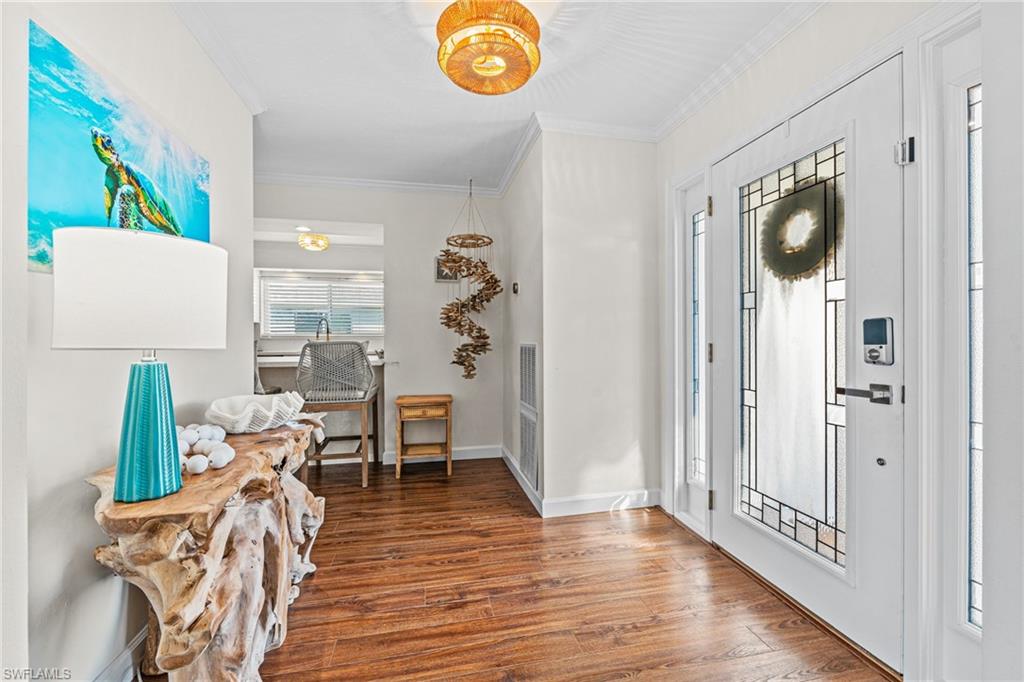 Entrance foyer featuring wood finished floors and ornamental molding