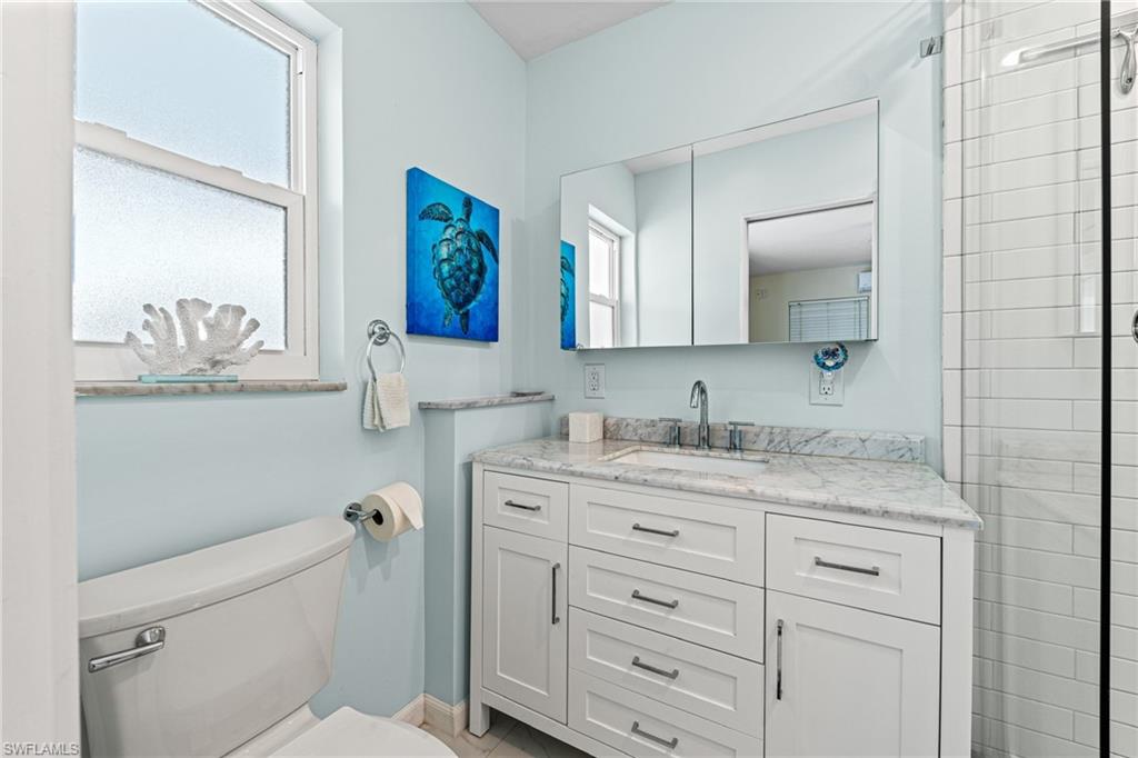 Full bathroom featuring plenty of natural light, vanity, and tiled shower