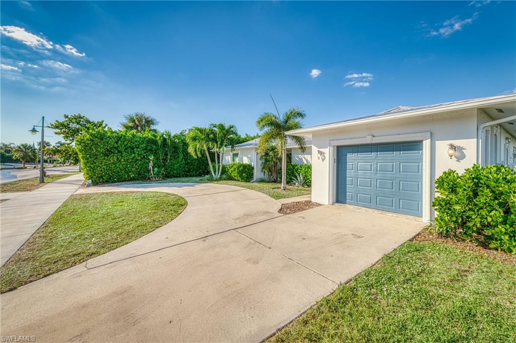 View of front facade featuring concrete driveway, stucco siding, a garage, and a front lawn