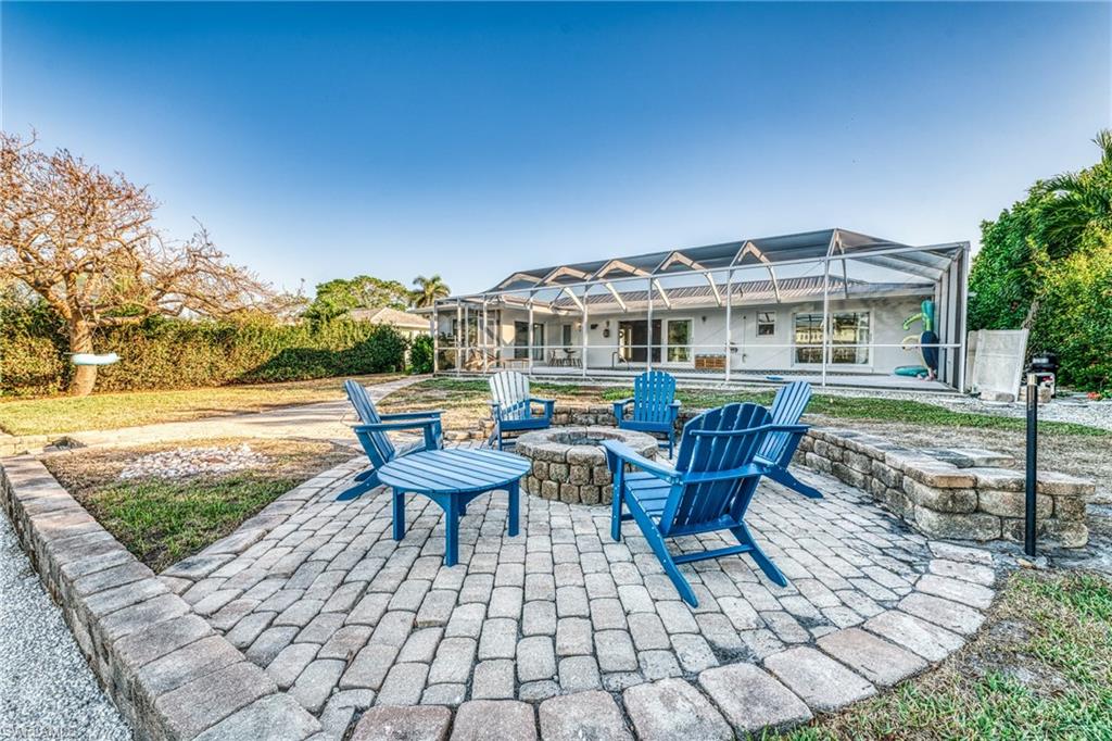 View of patio featuring glass enclosure and an outdoor fire pit