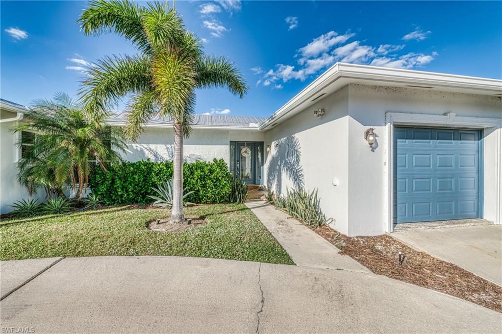 View of front of property with a garage, stucco siding, and concrete driveway