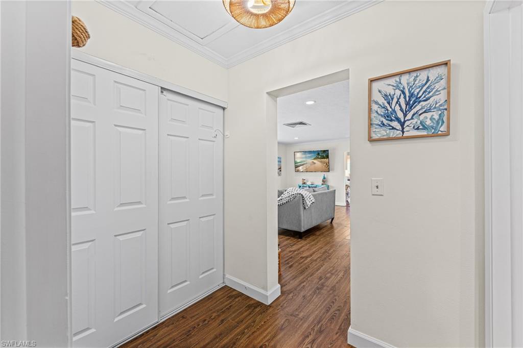 Corridor with crown molding and dark wood-style floors