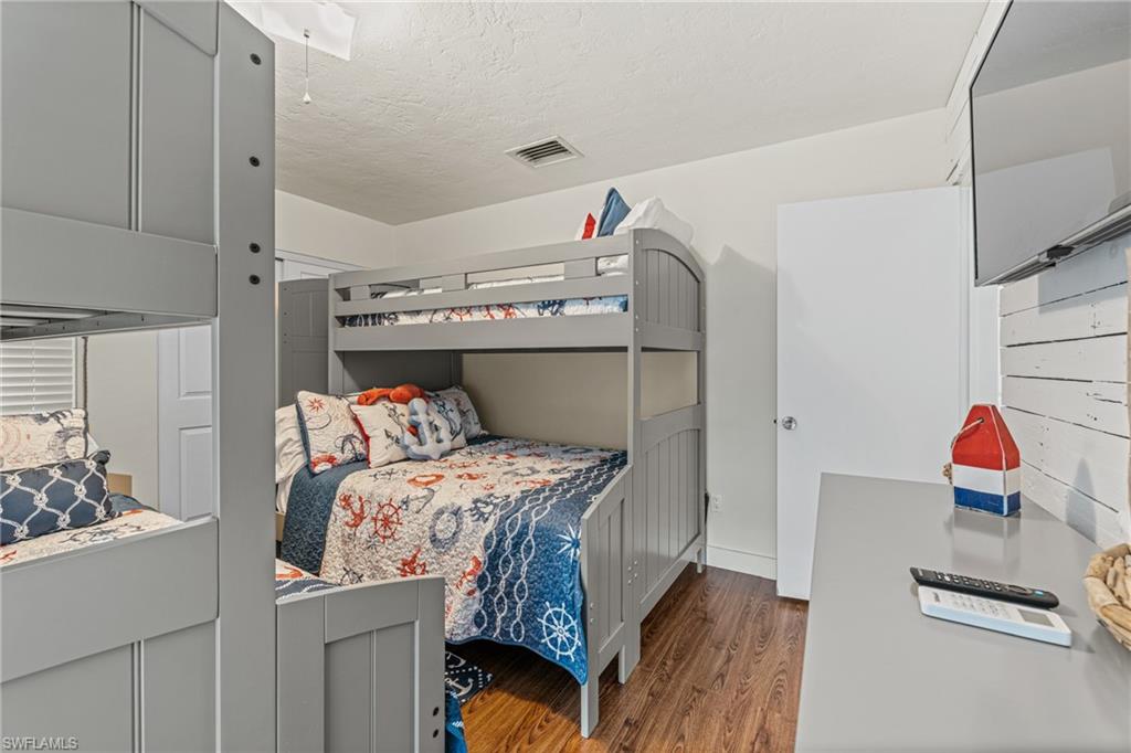 Bedroom with wood finished floors and a textured ceiling