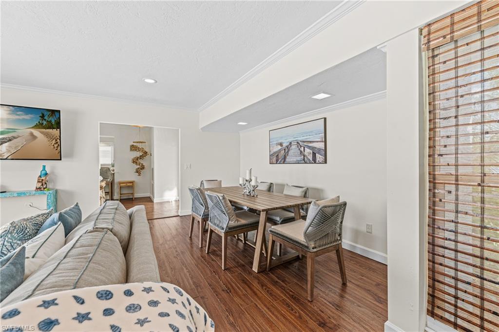 Dining space with ornamental molding, wood finished floors, recessed lighting, and a textured ceiling