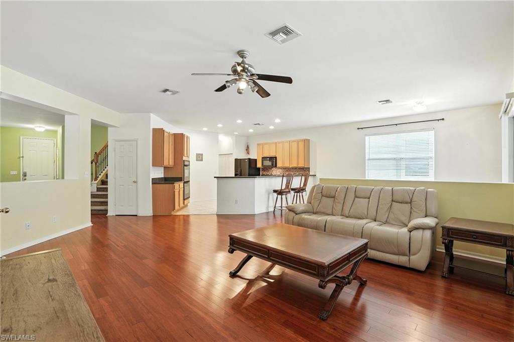 Living area featuring ceiling fan, wood finished floors, stairway, and recessed lighting