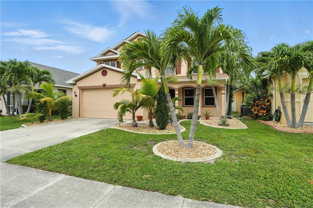 Mediterranean / spanish-style house with driveway, stucco siding, a front yard, and a garage