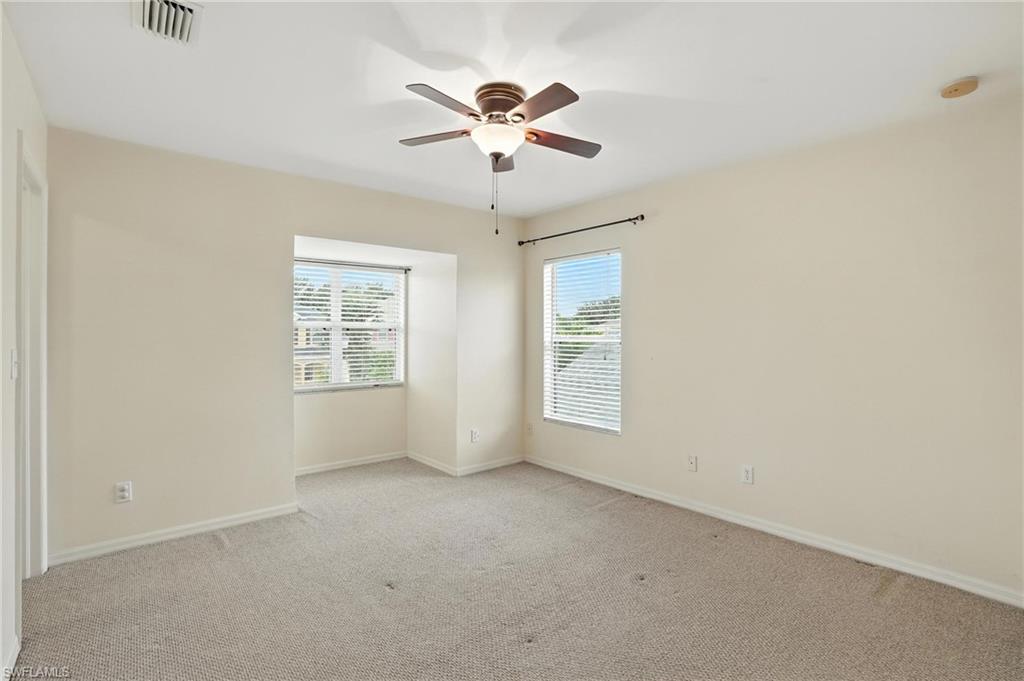 Unfurnished bedroom with light colored carpet, a ceiling fan, and a smoke detector