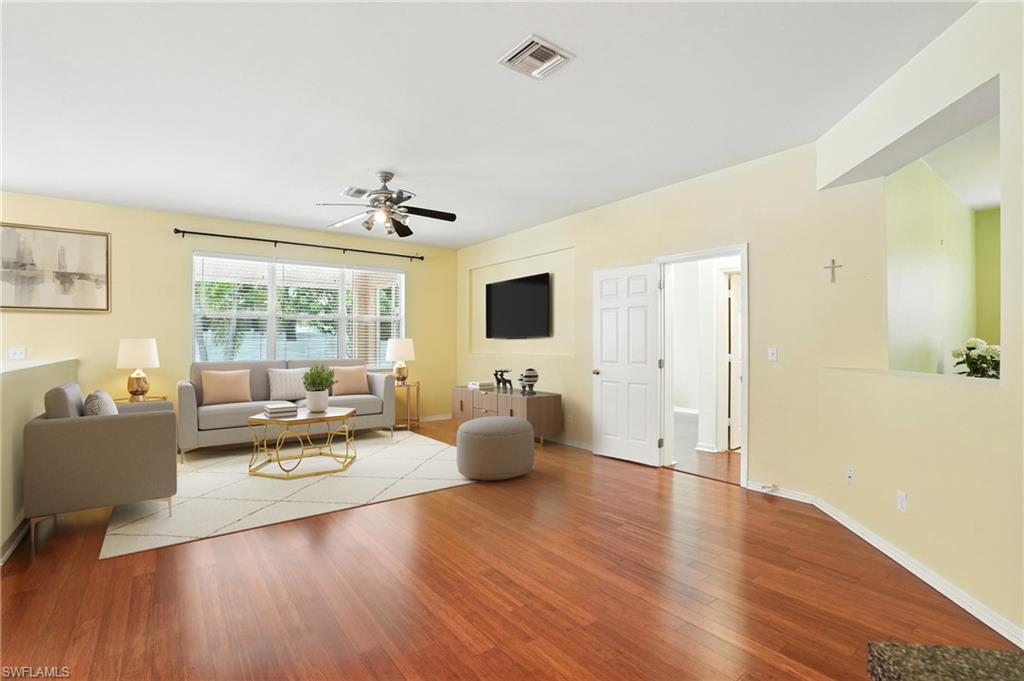 Living room featuring wood finished floors and ceiling fan (Virtually Staged)