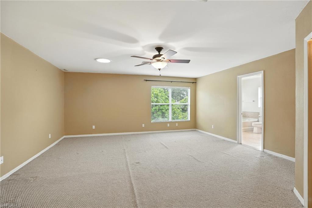 Unfurnished master bedroom with ceiling fan and light colored carpet