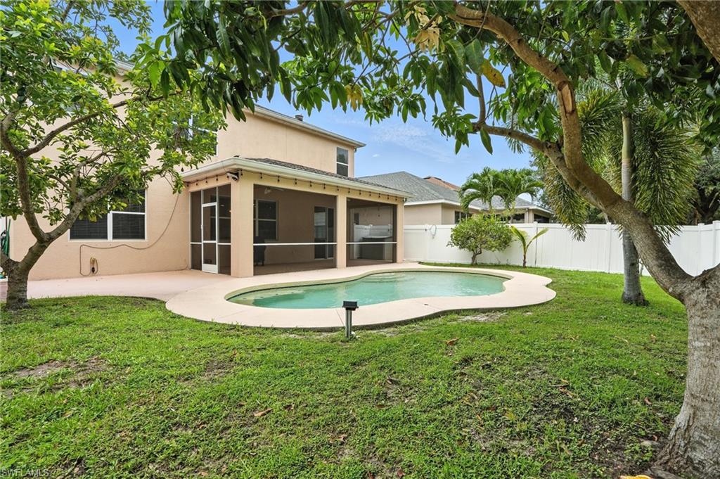 Back of house with a sunroom, a fenced backyard, stucco siding, and a patio area