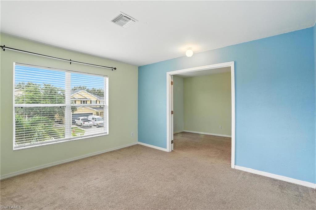 Carpeted spare room featuring baseboards