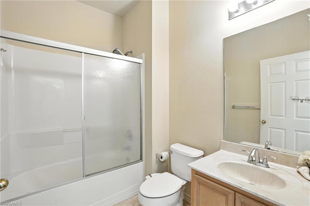 Bathroom featuring vanity and bath / shower combo with glass door
