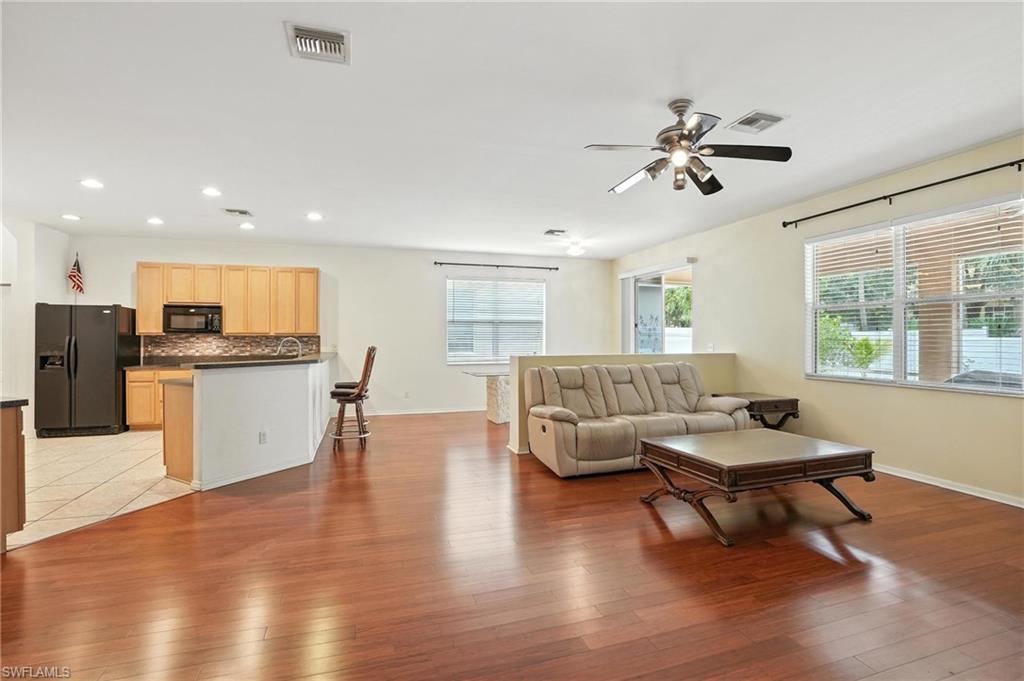 Living area with plenty of natural light, ceiling fan, light wood-style flooring, and recessed lighting