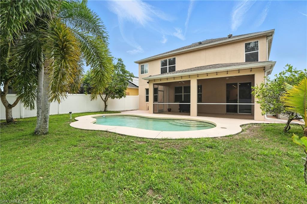 Rear view of house featuring a sunroom, stucco siding, a fenced backyard, and a patio
