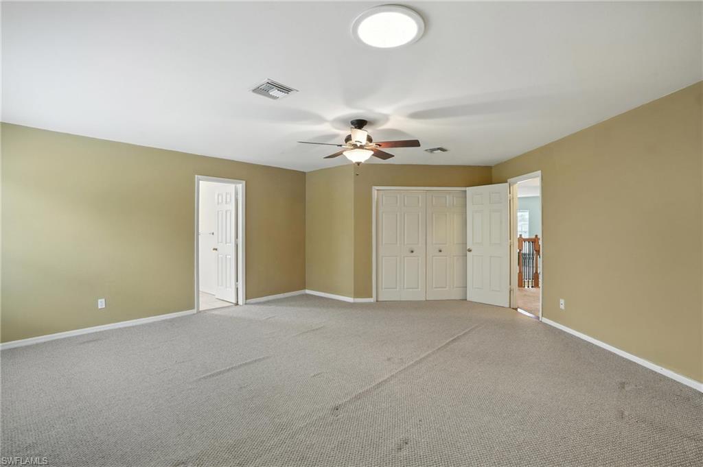 Unfurnished master bedroom with light carpet, ceiling fan, and a closet