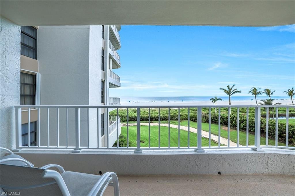 Balcony featuring view of water and beach