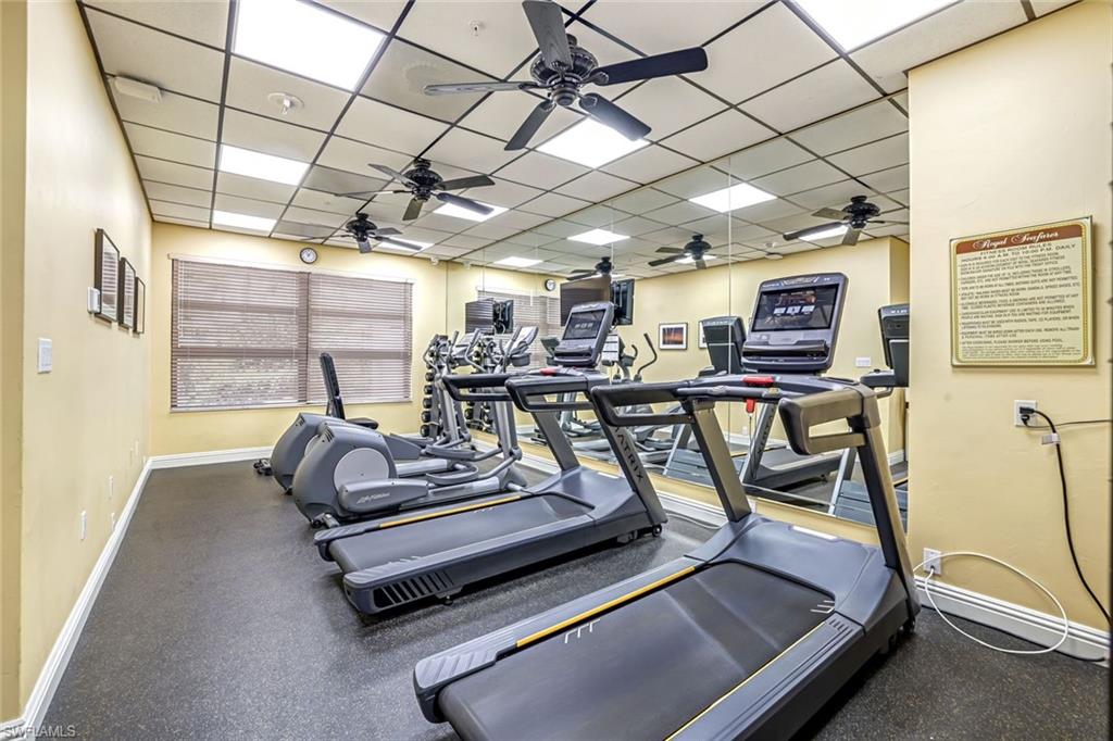 Gym with a paneled ceiling and ceiling fan