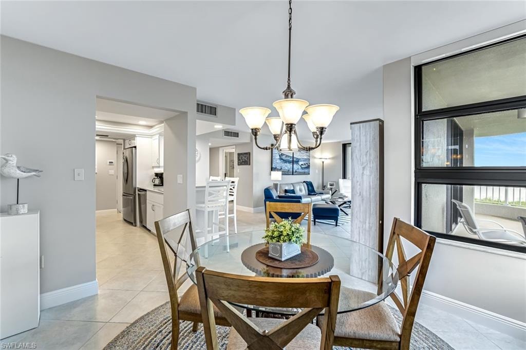 Dining area featuring a chandelier and light tile patterned flooring