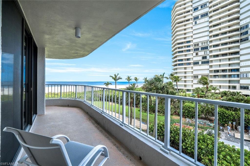 Balcony featuring view of water and beach