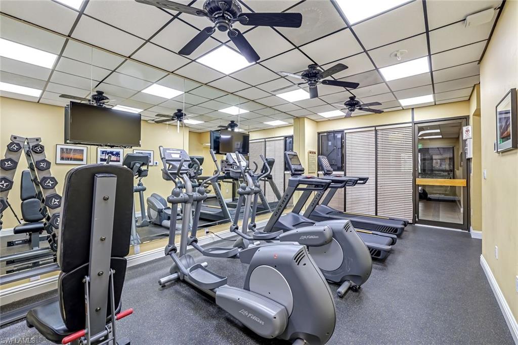 Workout area featuring a ceiling fan and a drop ceiling
