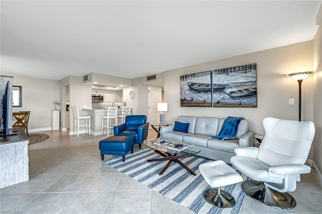 Living area featuring light tile patterned flooring and baseboards