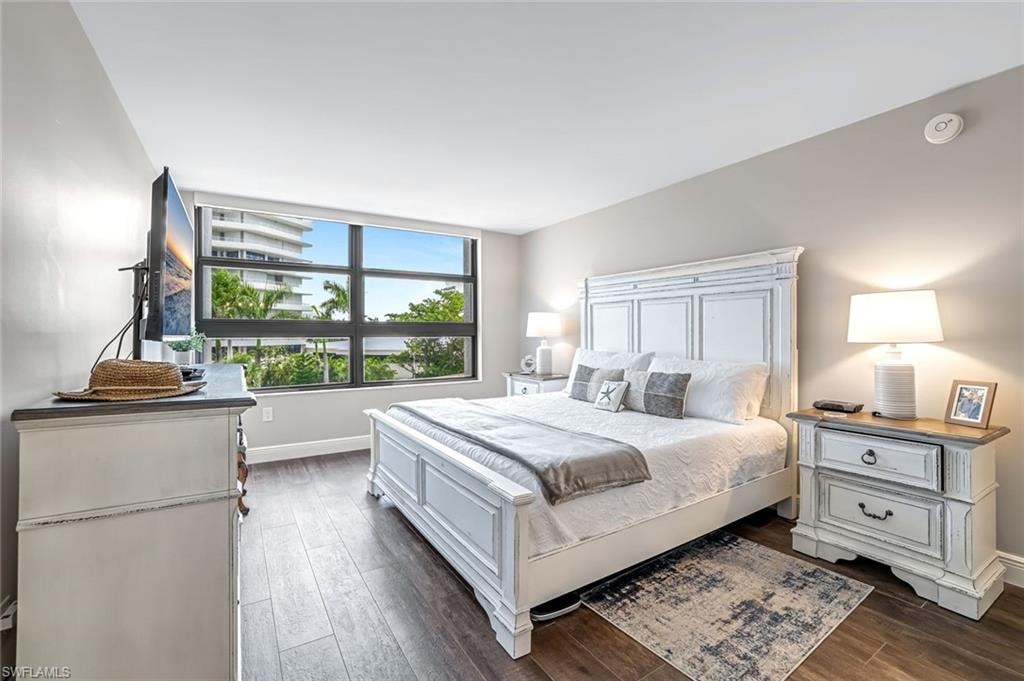 Bedroom featuring dark wood-style flooring and baseboards