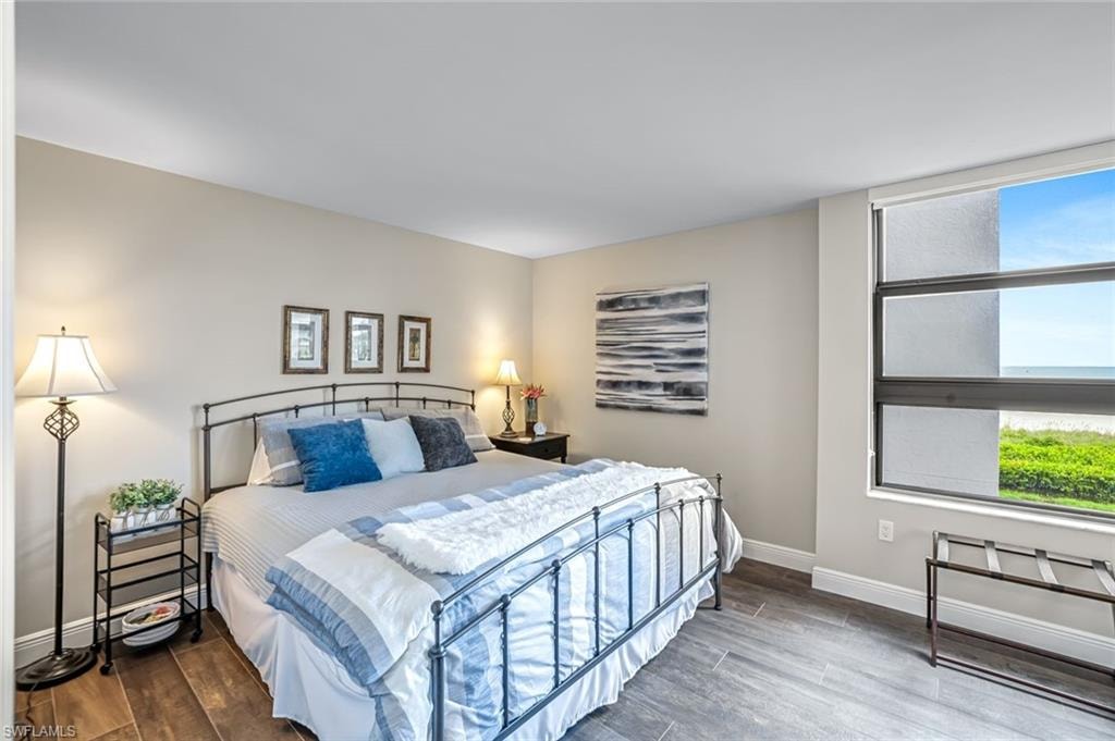 Bedroom with wood finished floors and baseboards