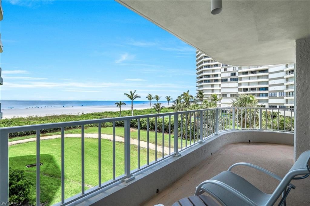 Balcony featuring view of water and beach