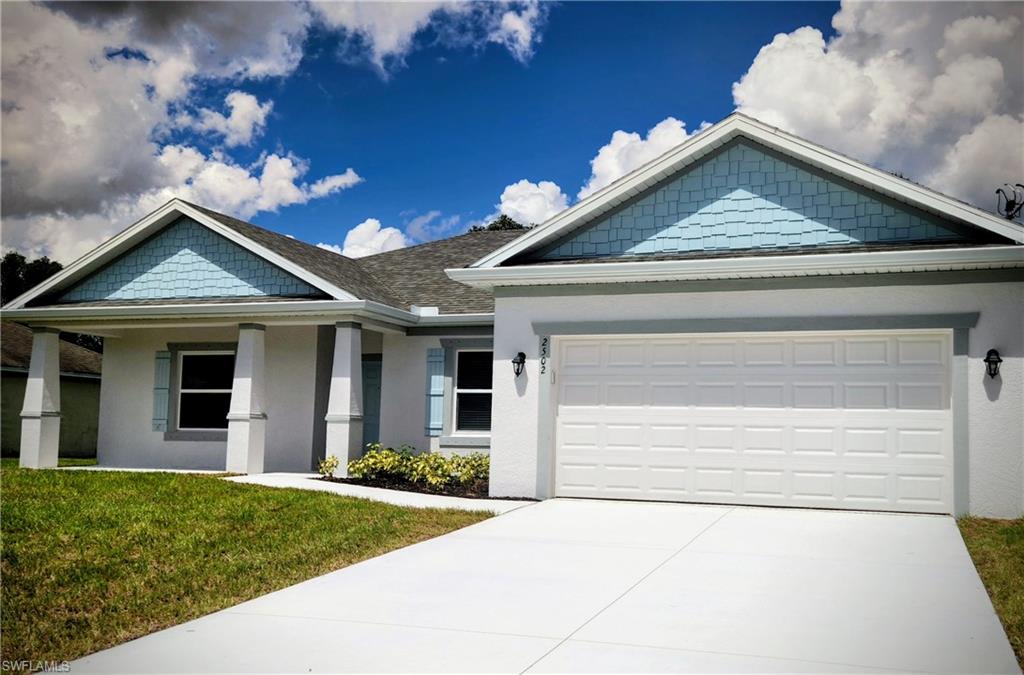 Craftsman inspired home featuring stucco siding, concrete driveway, a front yard, and a shingled roof