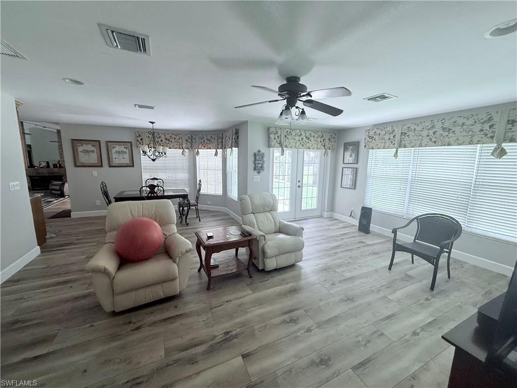 Living area with wood finished floors, a ceiling fan, and a chandelier