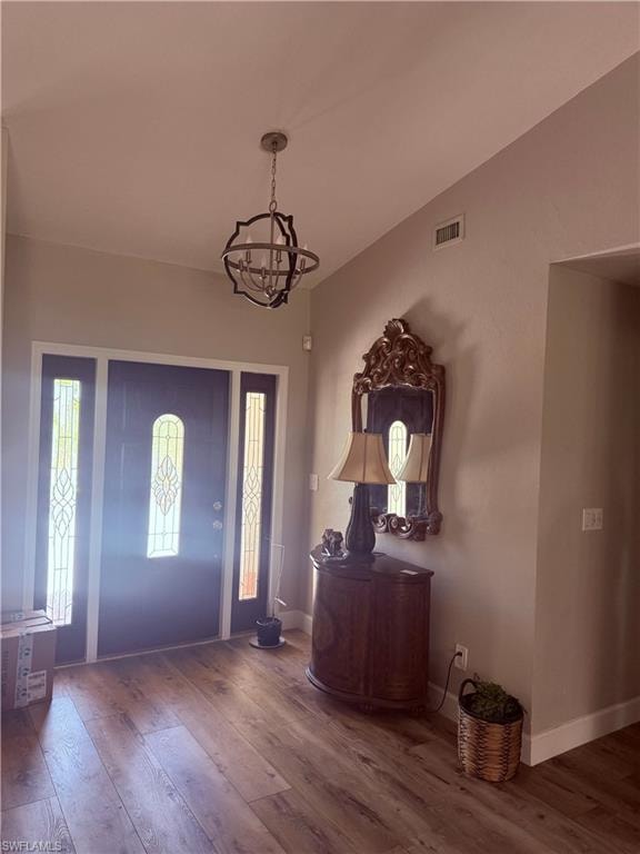 Foyer entrance with a chandelier and wood finished floors