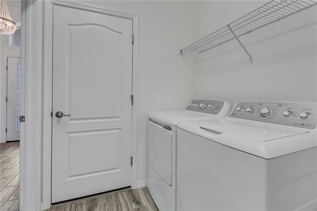 Laundry room featuring washer and clothes dryer and light finished floors